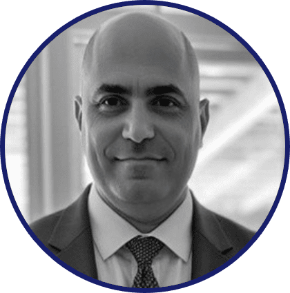 A professional black and white headshot of a man in a suit and tie.