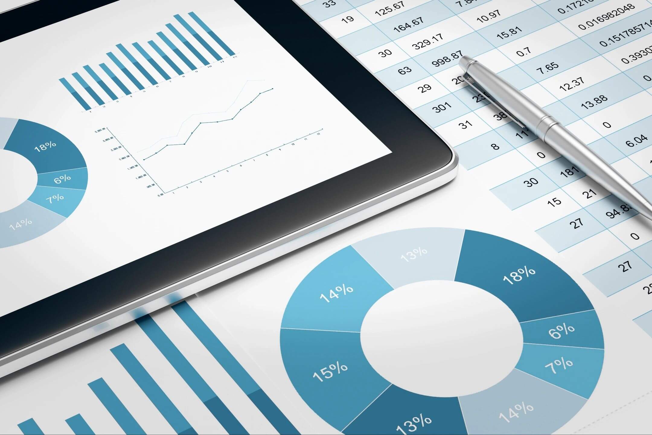 Tablet displaying a line chart alongside various blue-toned financial graphs.
